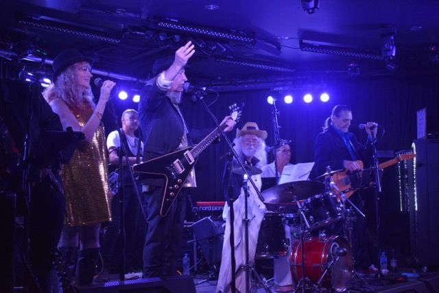 The band in full flight under blue light